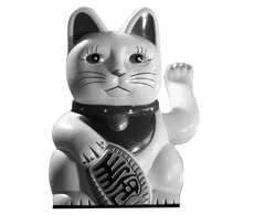 A black-and-white maneki-neko, the Japanese beckoning cat, raising one paw for luck.